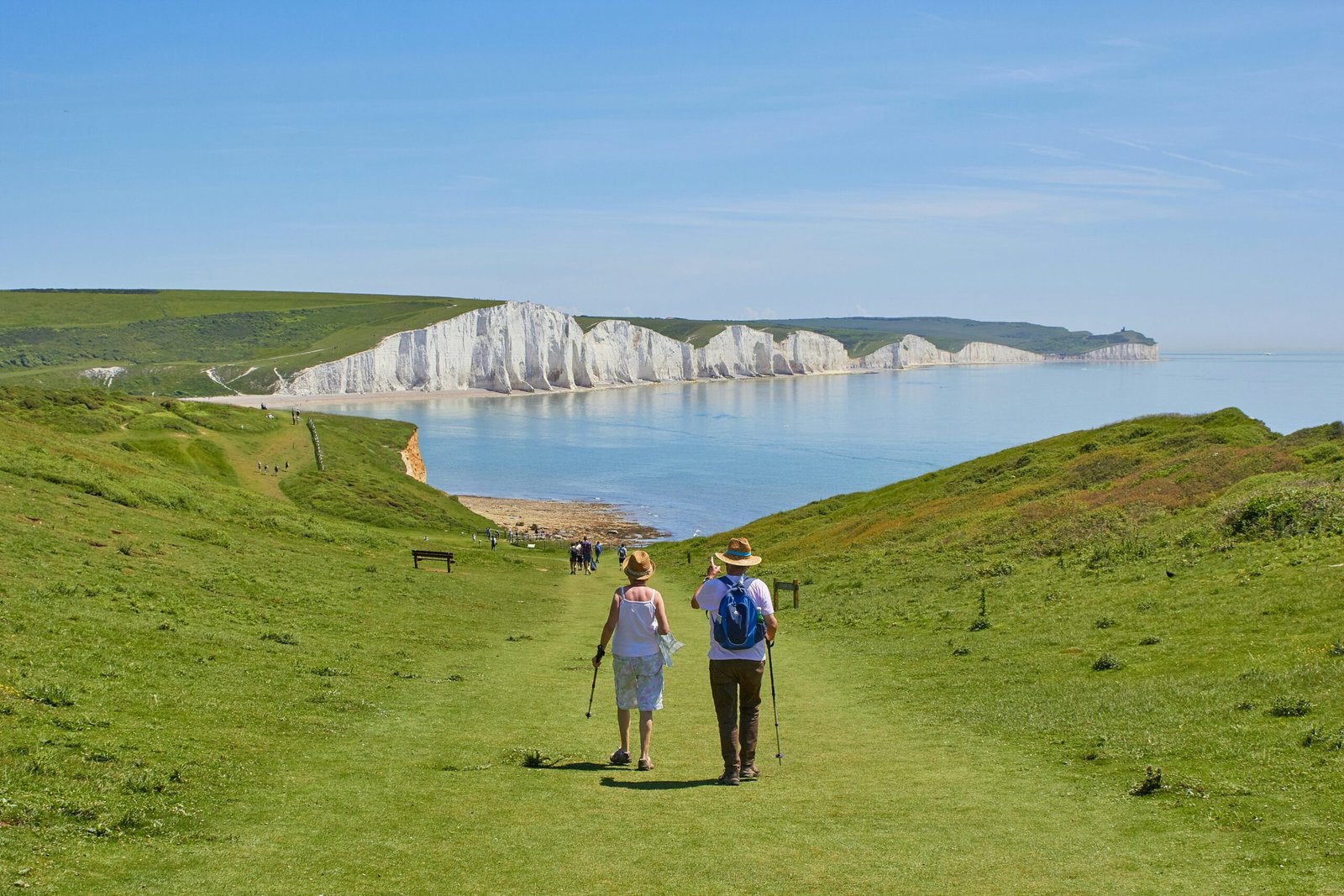 2 men standing on green grass field near body of water during daytime